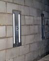 an inside view of foundation wall anchors installed along a basement wall to brace and repair the structure in Ozone Park