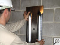 Mounting a foundation wall plate for an earth anchor installation in Woodside.