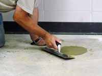 Repairing the cored holes in the concrete slab floor with fresh concrete and cleaning up the Elmhurst home.