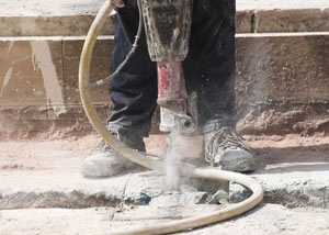Jackhammering a slab floor in a Queens home.