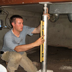 A contractor in Woodside installing a crawl space jack post.