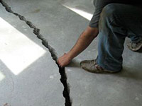a severely damaged cracked concrete slab floor in Rego Park