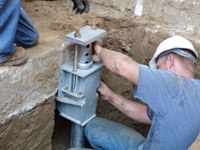 Foundation repair contractors installing the foundation bracket in Bronx.