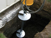 Installing a helical pier system in the earth around a foundation in Manhattan