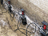 Using foundation push piers to lift a foundation during a repair in Ridgewood.