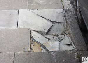 photo of a sinking concrete sidewalk with cracks in Saint Albans