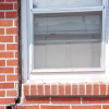 A gap in a window along the outer wall due to foundation settlement of a Ozone Park home.