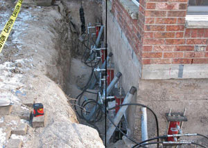 Foundation push piers installed around a house with a foundation settlement issues in Middle Village