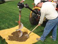 Auguring a hole in the earth for a foundation wall repair system in Elmhurst