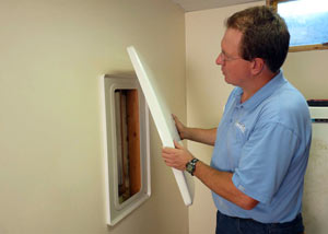Foundation wall anchor covers installed in a finished basement with a repaired foundation wall in Middle Village.