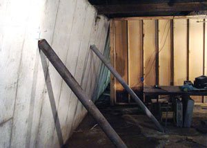 A severely tilting foundation wall propped up by steel beams in Rockaway Park.