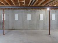A repaired basement wall with foundation wall anchor covers installed in Queens.