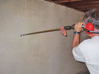 Drilling the hole in the foundation wall for street creep repairs in Saint Albans