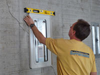 Positioning a wall plate cover on a foundation wall in Astoria.