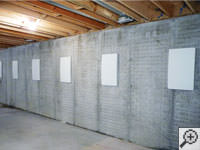 Wall anchor covers installed along a foundation wall that has been straightened in Rockaway Park.