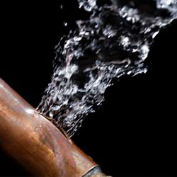 A bursting copper pipe in Manhattan, with water gushing out.