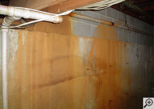 Iron ochre stains on a basement wall, where the pipes have leaked.