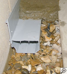 A no-clog basement french drain system installed in Queens